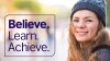 Eine Frau mit einer Mütze lächelt in die Kamera, eine Box zu ihrer Linken sagt "Believe. Learn. Achieve"