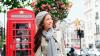 Eine Frau vor einer roten Telefonzelle
