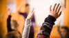 An image of students' hands raised